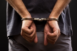 Man in handcuffs representing domestic violence and harassment 